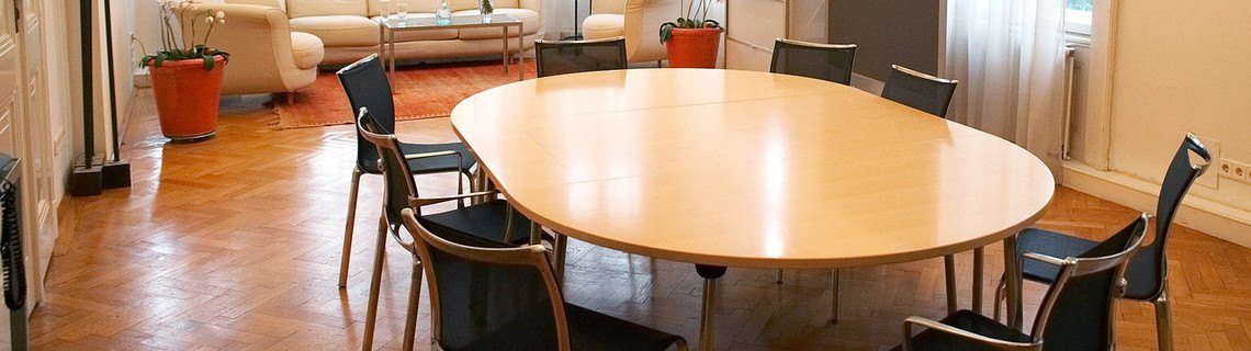 Konferenztisch für eine Tagung in einem hellen Altbau-Wohnzimmer mit Parkett Konferenztisch für eine Tagung in einem hellen Altbau-Wohnzimmer mit Parkett